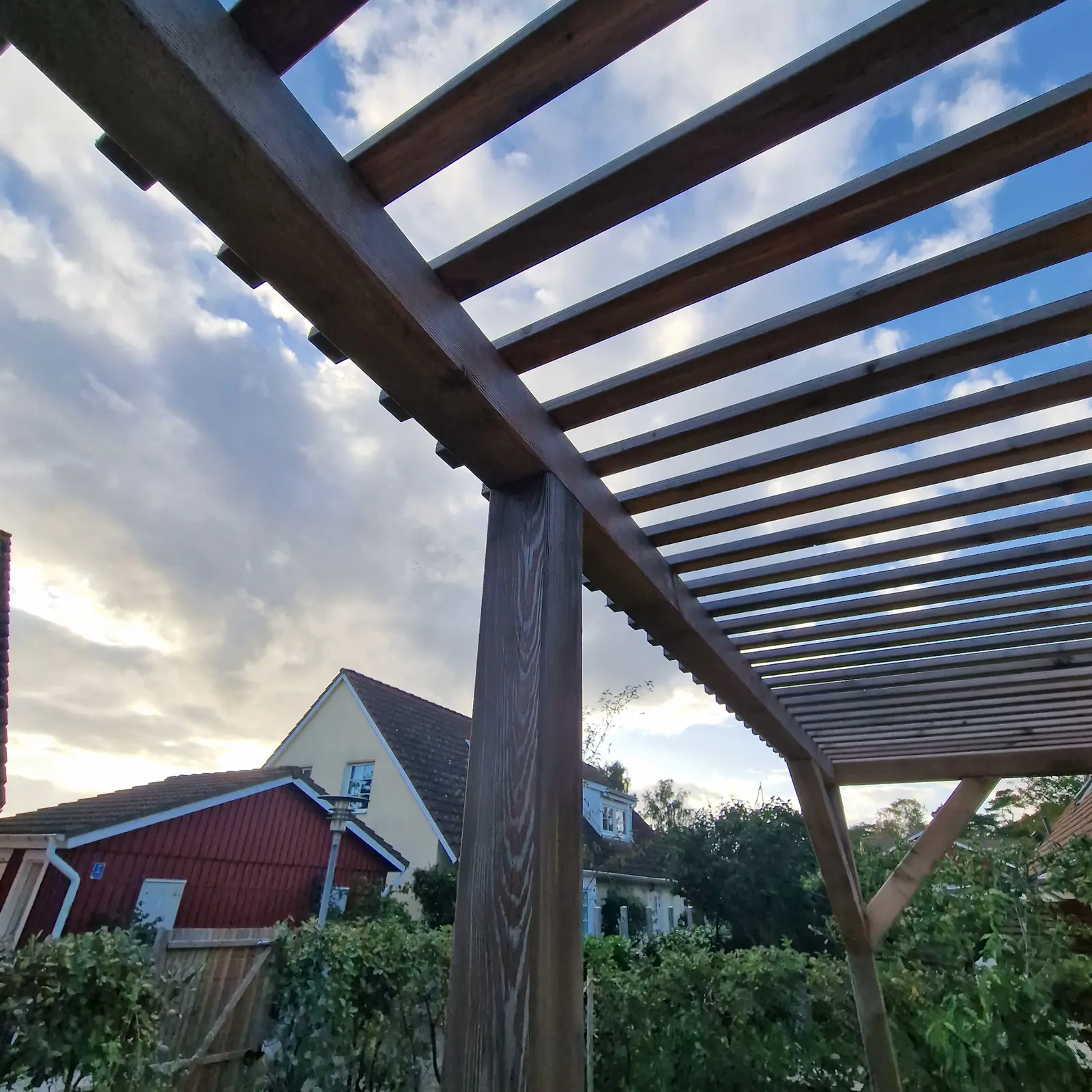 Terrasse med træpergola og belægning